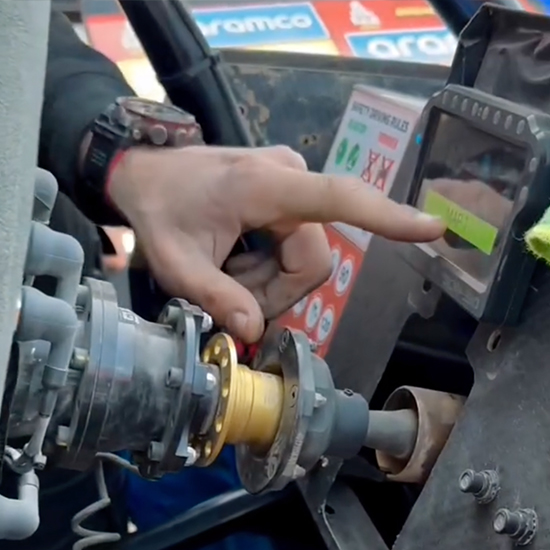 BBR Motorsport team member pointing to the MAP screen on the PLEX SDM-330 display during Dakar 2025.