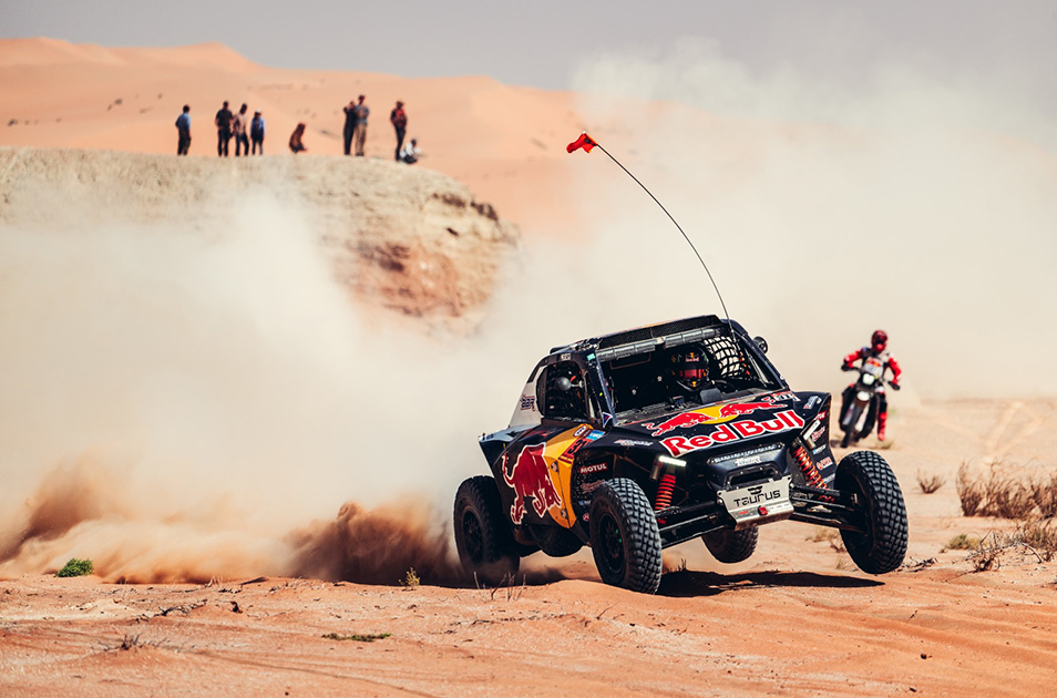 BBR Motorsport Taurus T3 Max lifting on two wheels in the desert during Dakar 2025, with spectators watching in the background.